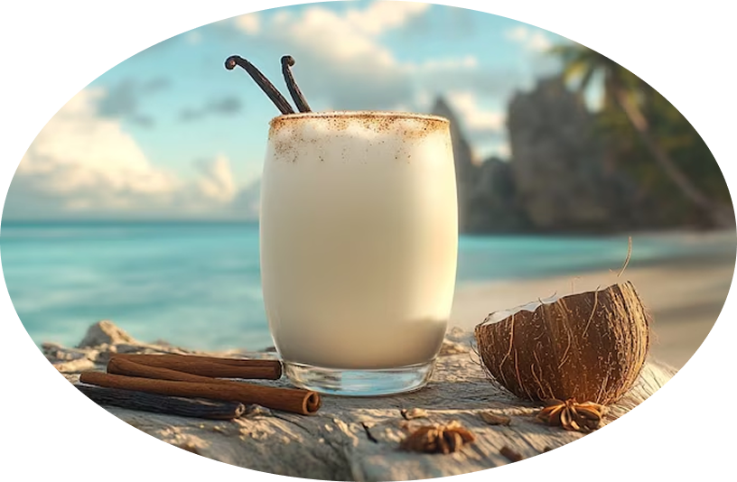 Pitorro de coco en un vaso, sobre madera, con coco y canela junto al mar